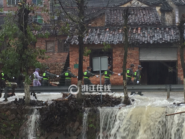 水流湍急，救援人员手拉手往前走。　（浙江日报记者 吴勇）.jpg