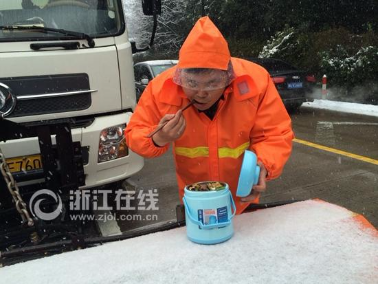 2016年1月，杭州大雪，环卫工人乘着扫雪空隙扒几口热饭。.jpg