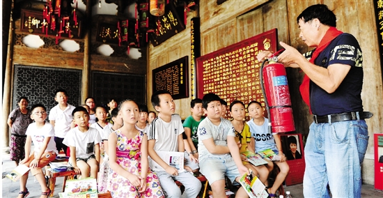 日前，东阳市江北街道甘东文化礼堂，消防志愿者在给孩子们讲解日常用火等安全常识。　包康轩　摄.jpg